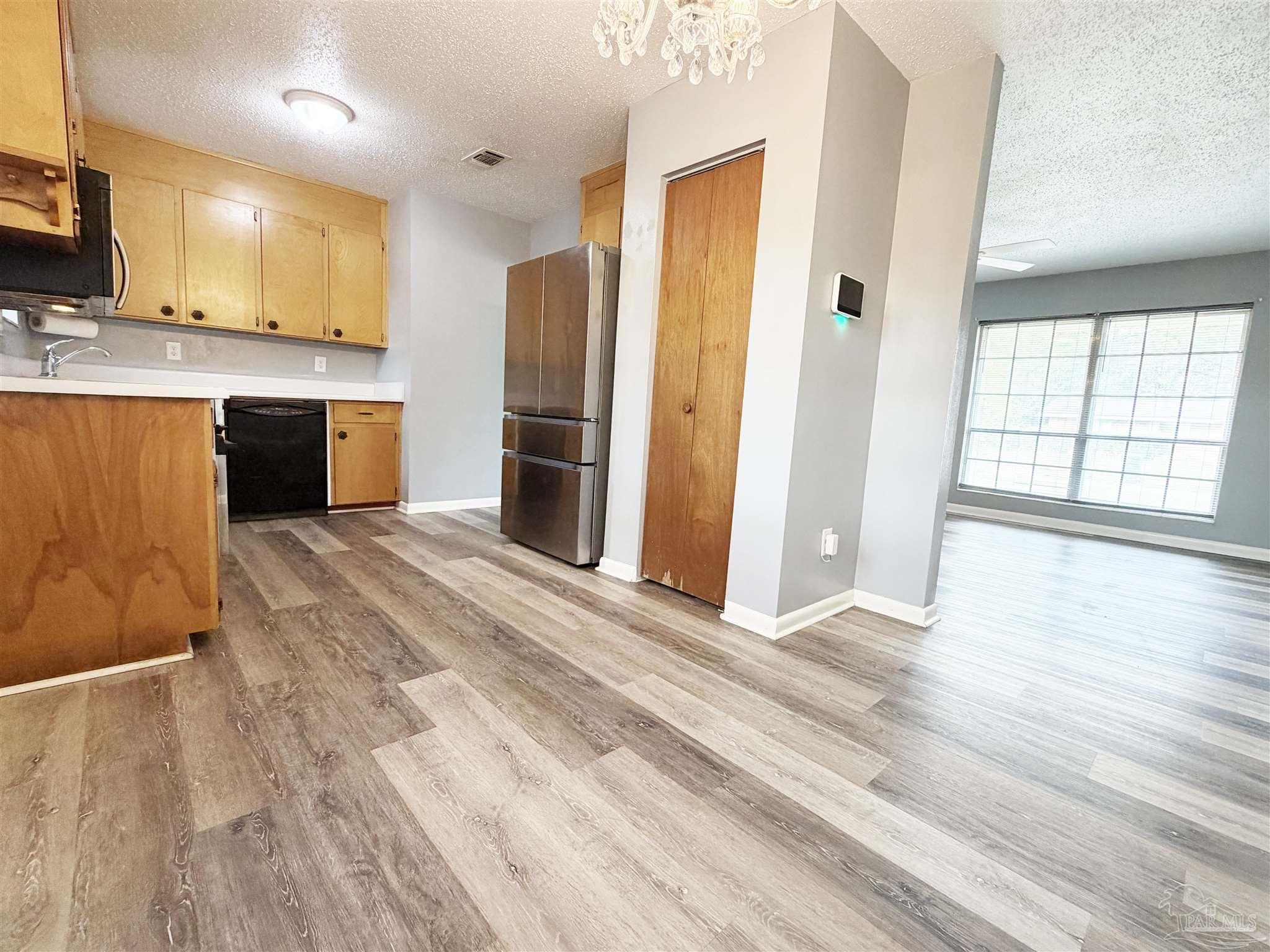 2053 Tomlinson Road Pensacola, FL 32526 - Photo 6 of 27 a large kitchen with stainless steel appliances wooden floors and large window