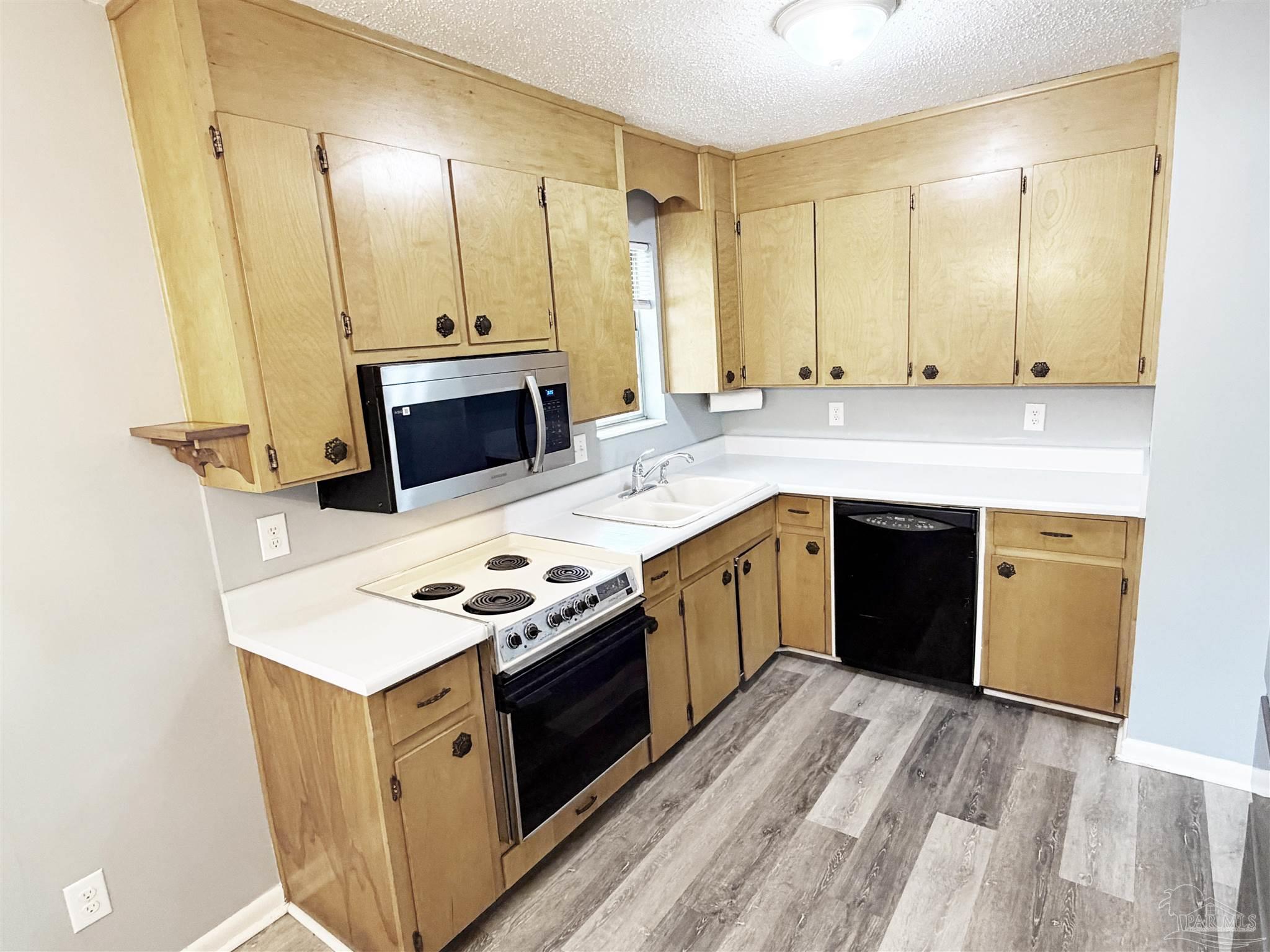2053 Tomlinson Road Pensacola, FL 32526 - Photo 8 of 27 a kitchen with stainless steel appliances granite countertop a stove a sink and a refrigerator