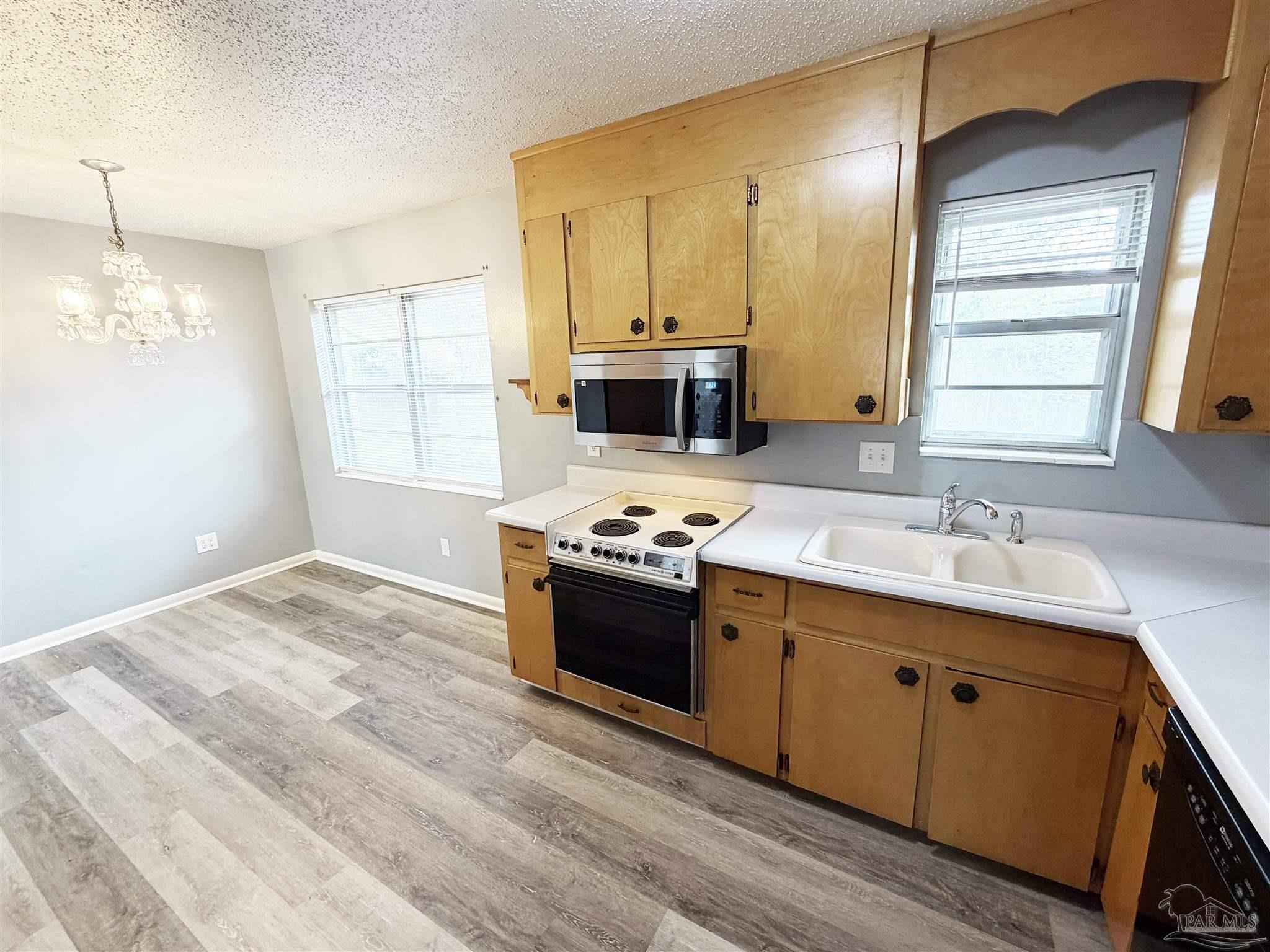 2053 Tomlinson Road Pensacola, FL 32526 - Photo 9 of 27 a view of a kitchen with a sink and dishwasher a fireplace with wooden floor