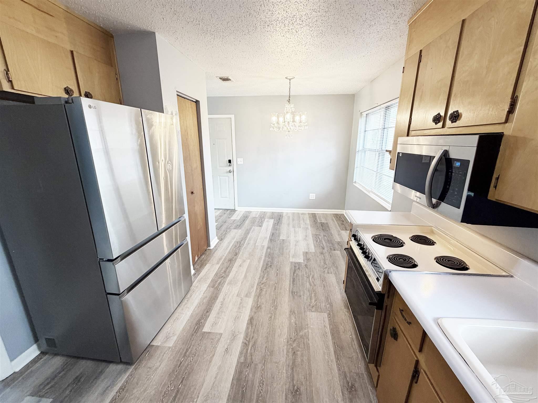 2053 Tomlinson Road Pensacola, FL 32526 - Photo 10 of 27 a kitchen with a refrigerator a sink and cabinets