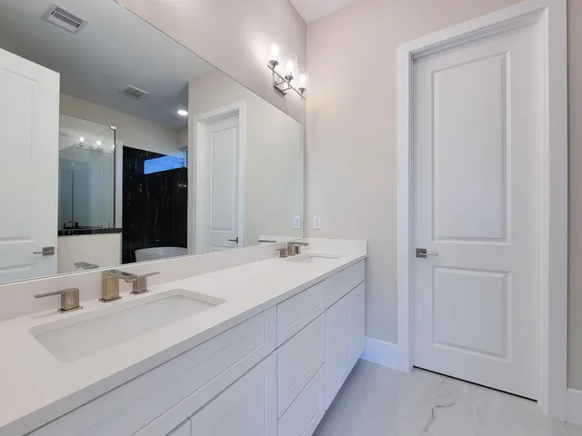 a bathroom with a double vanity sink mirror and