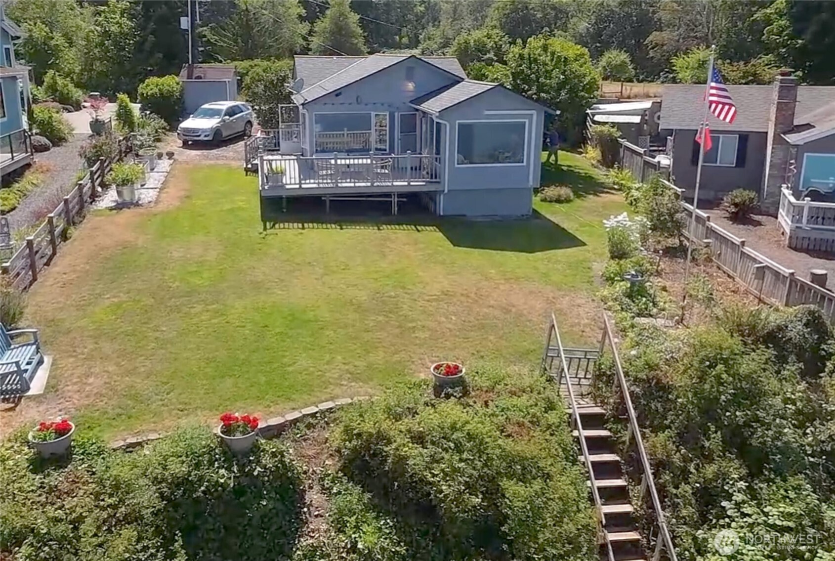 a view of a house with a big yard and potted plants