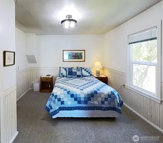 a spacious bedroom with a bed and a window