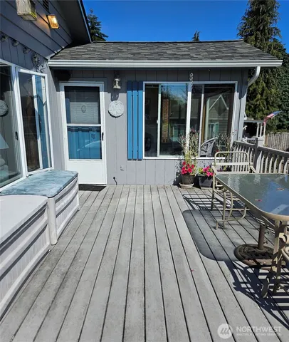 a view of outdoor sitting space with wooden floor and barbeque