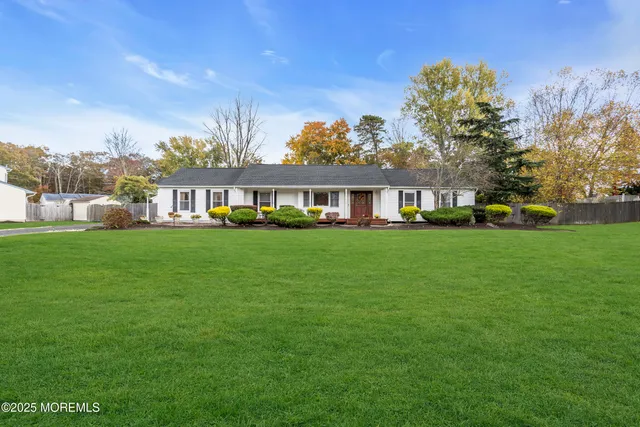 a front view of a house with garden and trees