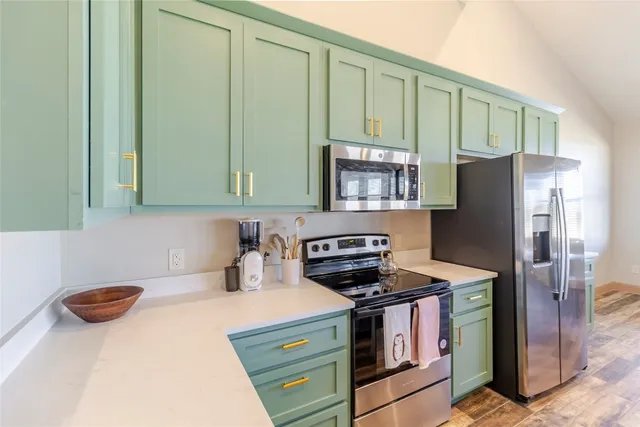 a kitchen with stainless steel appliances a stove a refrigerator a sink and cabinets