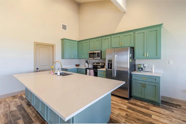 a kitchen with kitchen island a sink refrigerator and microwave