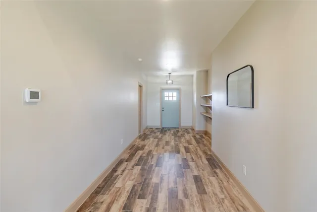 a view of a livingroom with wooden floor and front door