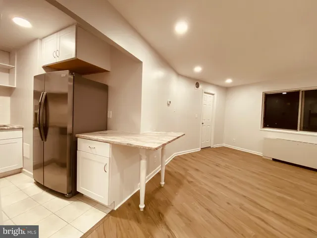 a kitchen with stainless steel appliances kitchen island granite countertop a refrigerator and a stove top oven