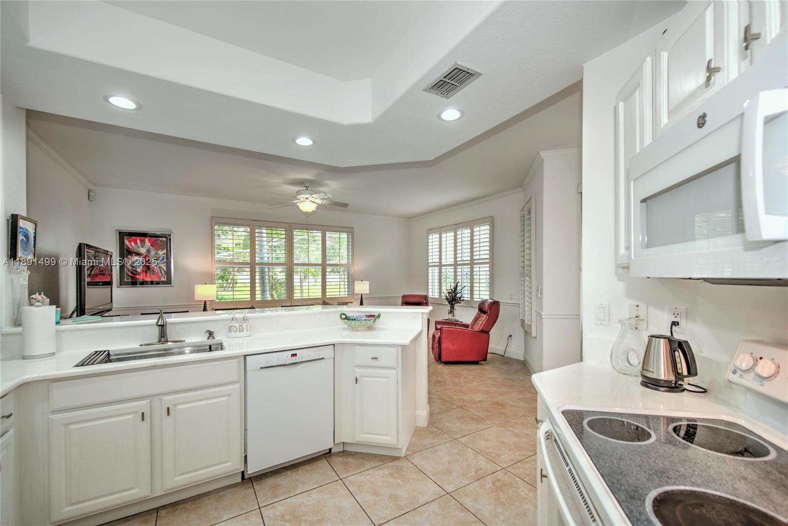 8385 Whisper Trace Way, Unit 104 Naples, FL 34114 - Photo 11 of 18 a kitchen with a sink stove top oven and cabinets