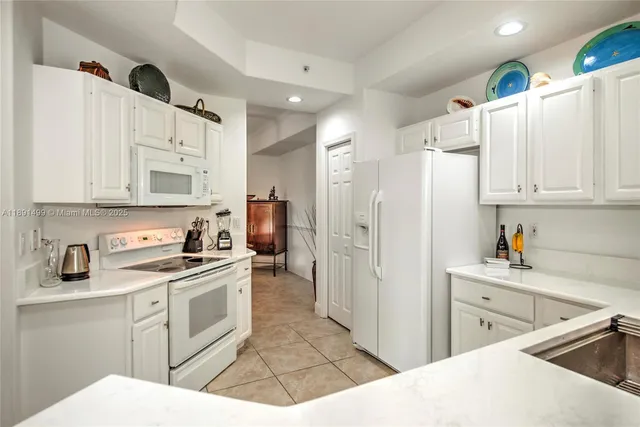 a kitchen with white cabinets and white appliances