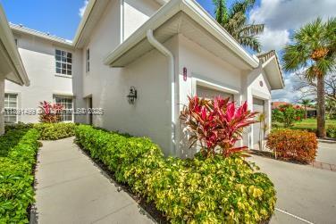 8385 Whisper Trace Way, Unit 104 Naples, FL 34114 - Photo 7 of 18 a front view of a house with a yard