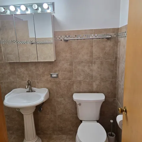 a bathroom with a toilet sink and mirror