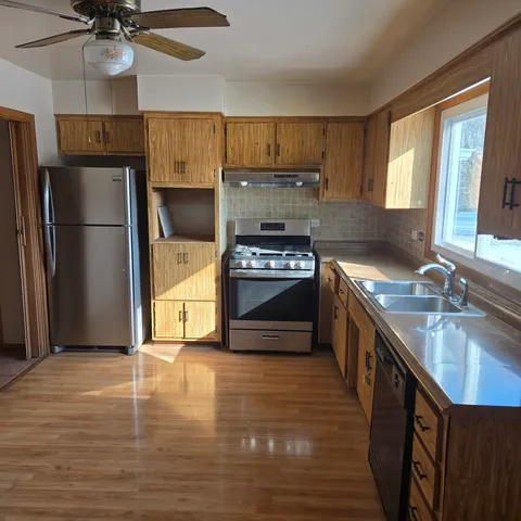 a kitchen with stainless steel appliances a stove a refrigerator and a sink