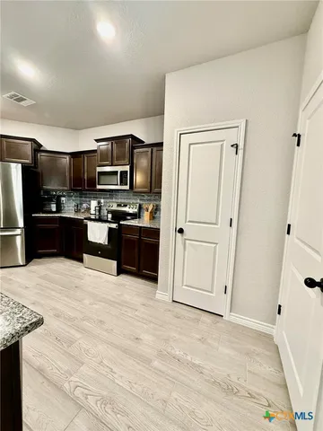 a large kitchen with cabinets and stainless steel appliances