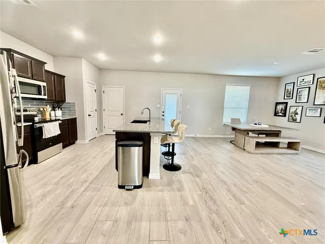 a kitchen with stainless steel appliances kitchen island granite countertop a sink and cabinets