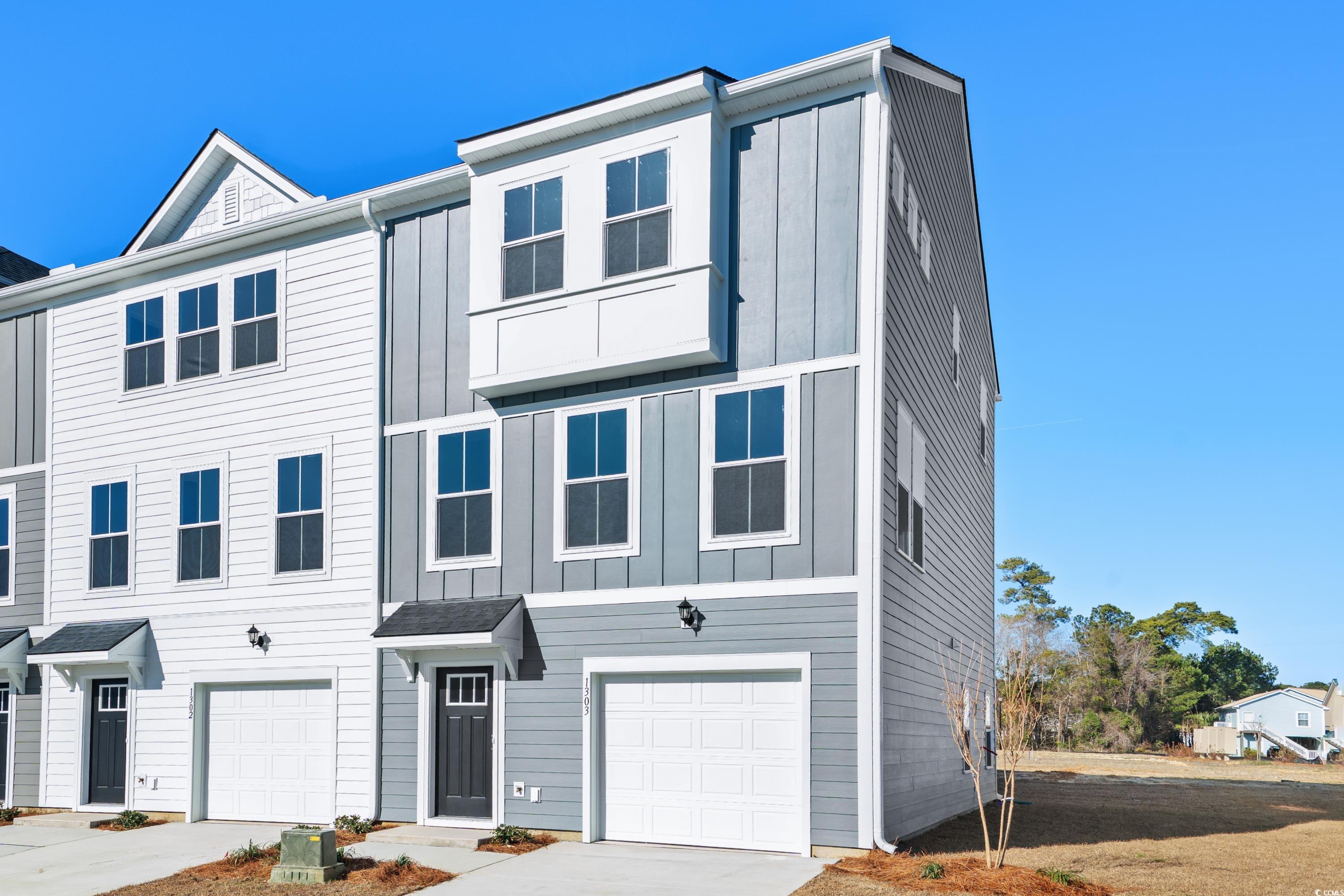 View of front of property featuring board and batten siding, a garage, and concrete driveway