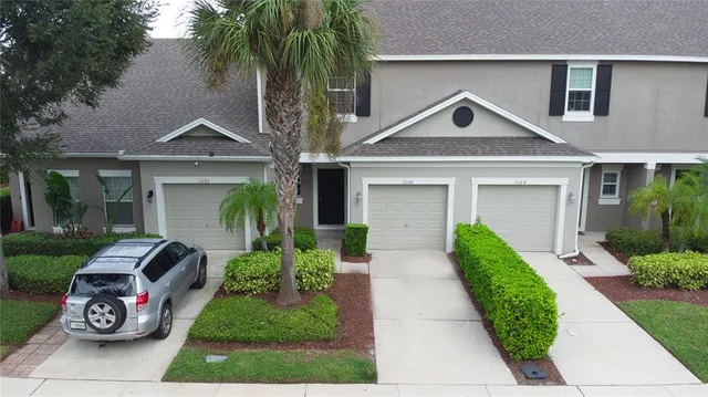 a front view of a house with a garden and plants