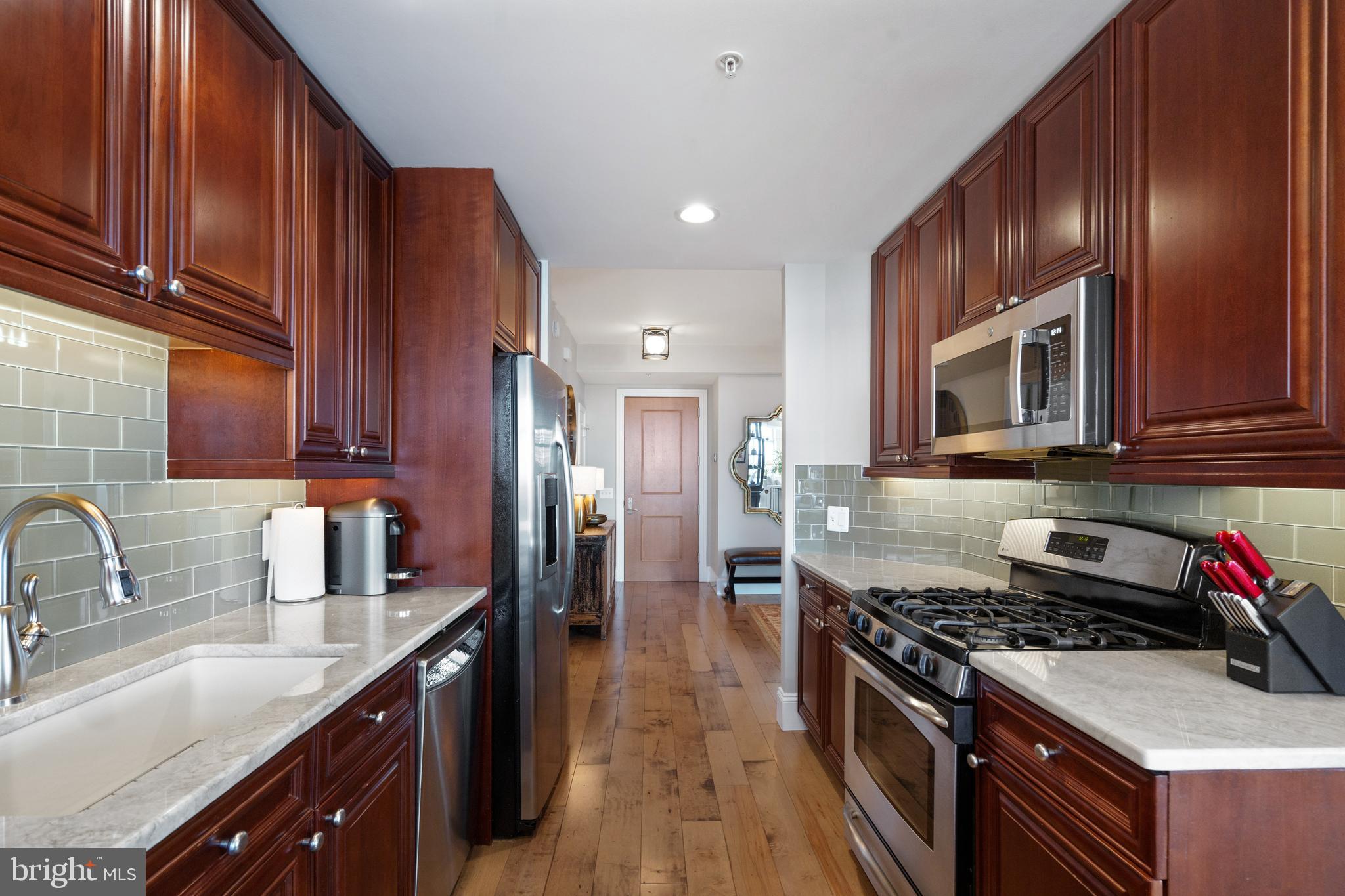 11990 Market Street, Unit 813 Reston, VA 20190 - Photo 5 of 48 a kitchen with stainless steel appliances granite countertop a stove a sink dishwasher and microwave oven with cabinets