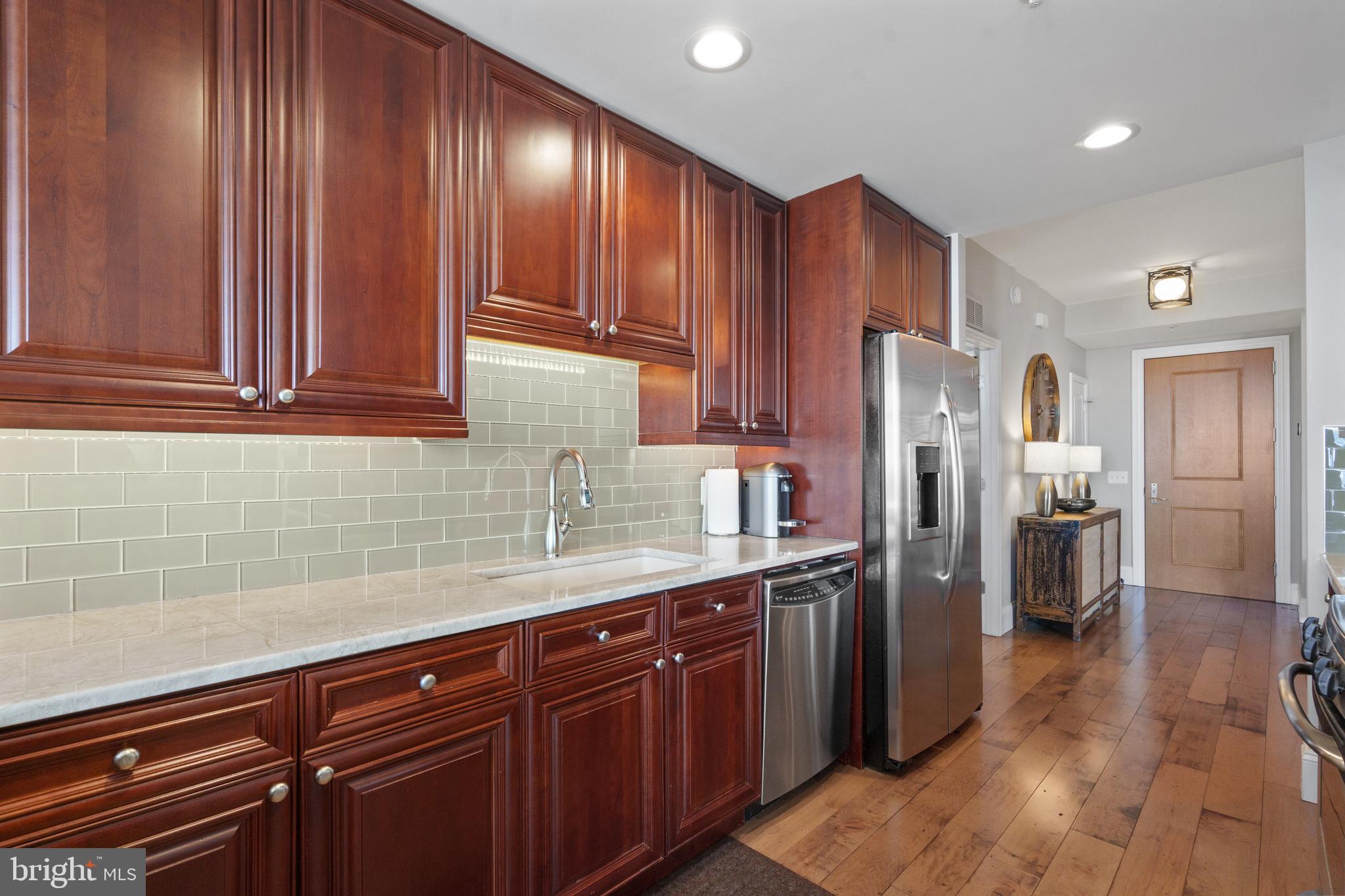11990 Market Street, Unit 813 Reston, VA 20190 - Photo 6 of 48 a kitchen with stainless steel appliances granite countertop a refrigerator and a sink