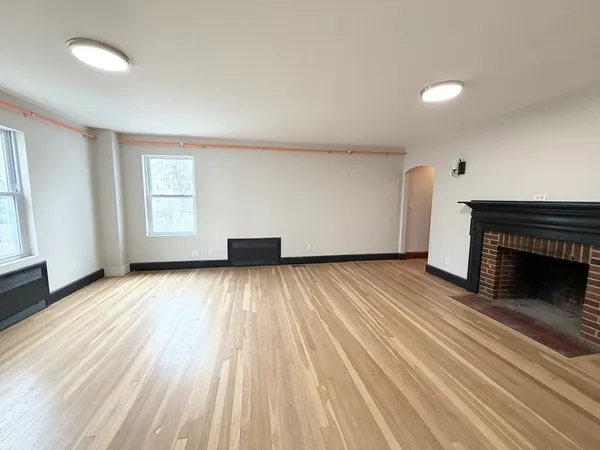 wooden floor in an empty room with a fireplace