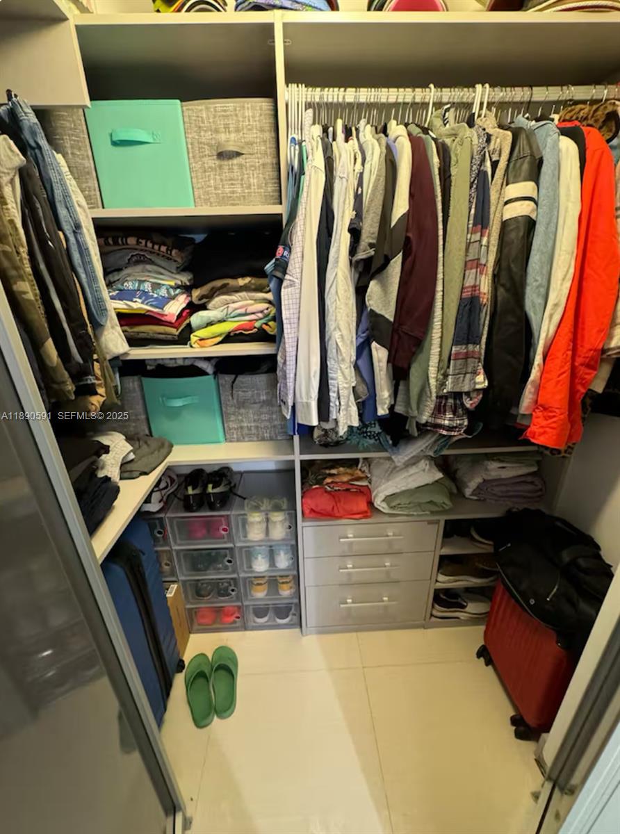 9240 Byron Avenue Surfside, FL 33154 - Photo 16 of 27 a view of walk in closet with clothes and shoes