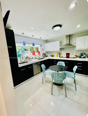 a kitchen with stainless steel appliances kitchen island granite countertop a sink and a refrigerator
