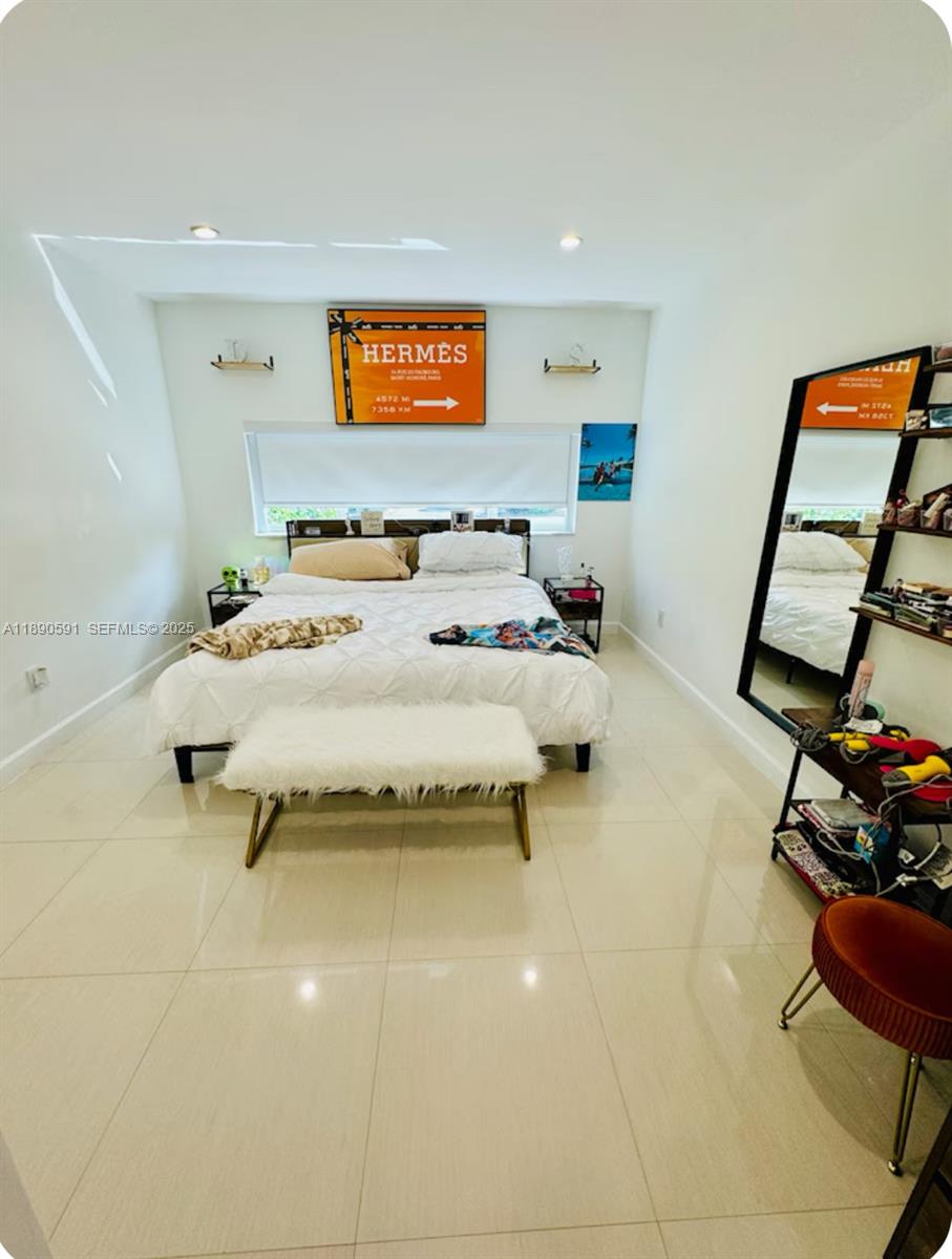 9240 Byron Avenue Surfside, FL 33154 - Photo 21 of 27 a bedroom with a bed and furniture