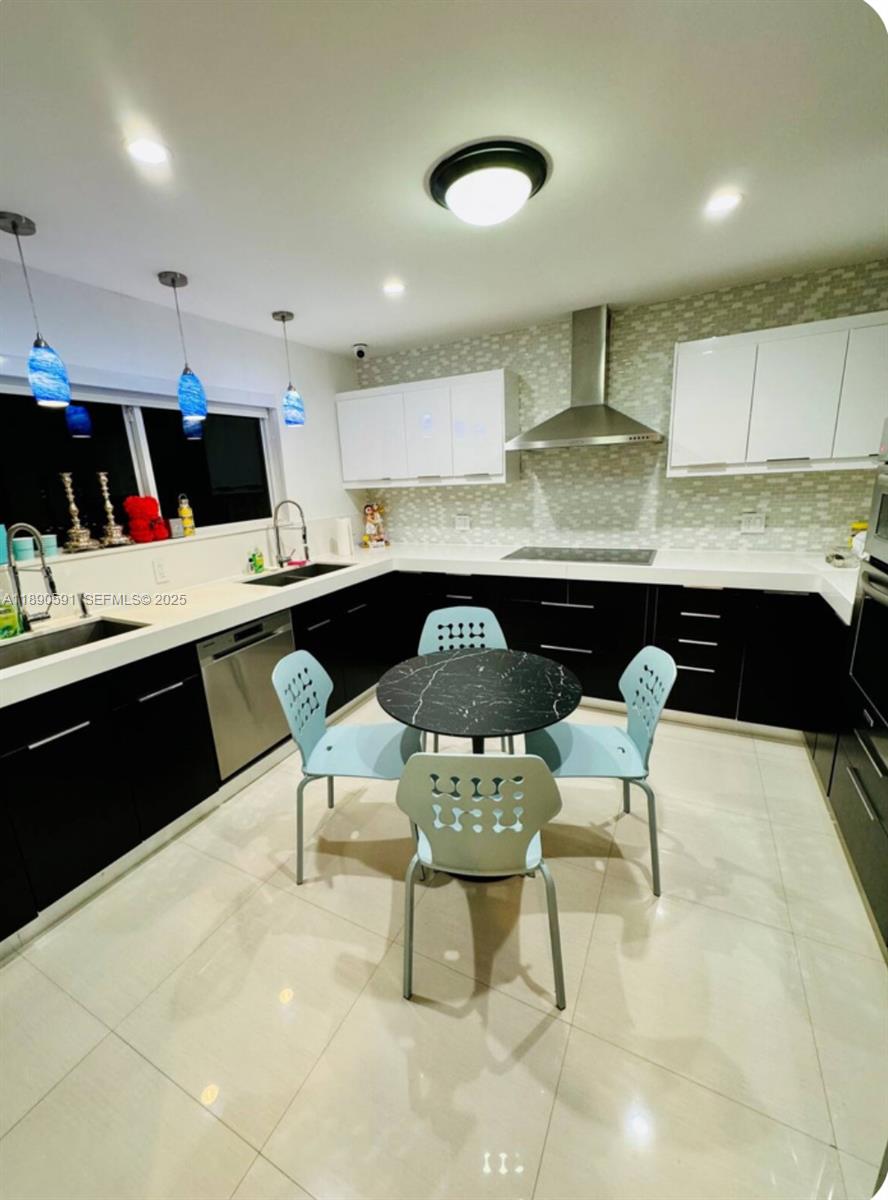 9240 Byron Avenue Surfside, FL 33154 - Photo 23 of 27 a kitchen with a table chairs sink and cabinets