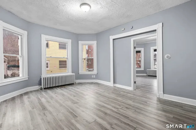an empty room with wooden floor and windows