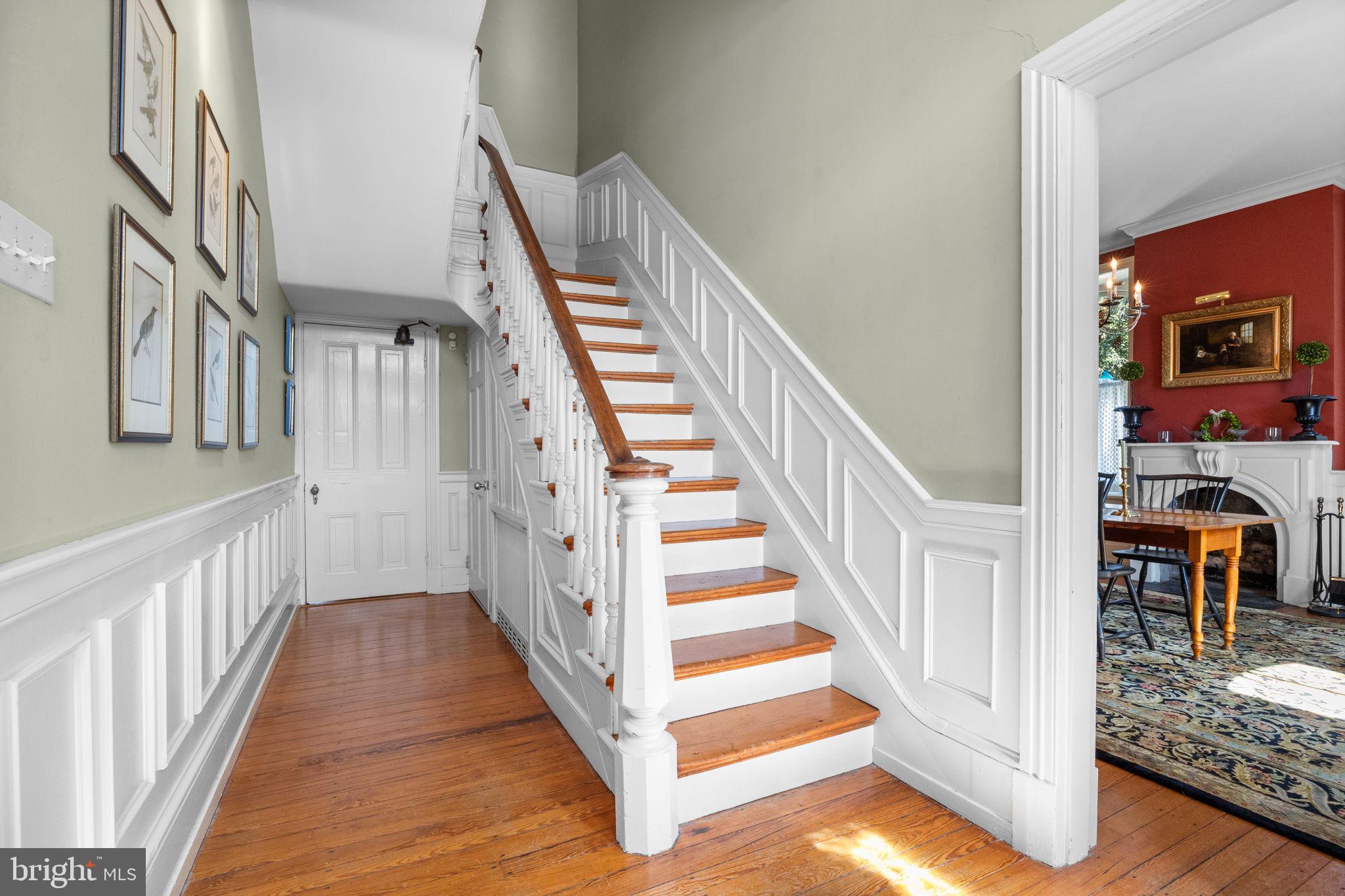 411 East Mill Road Flourtown, PA 19031 - Photo 7 of 62 a view of staircase with lots of frames on wall and a dining table