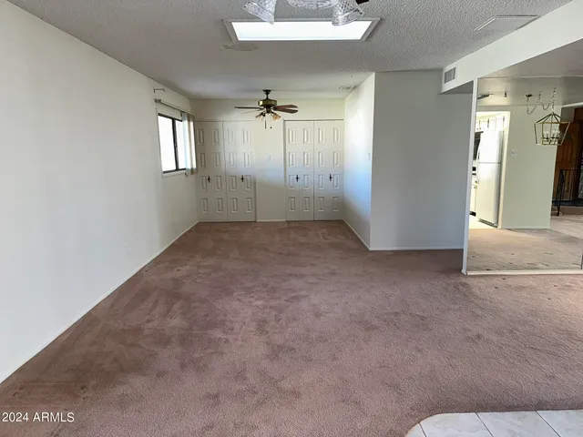 an empty room with windows and cabinet