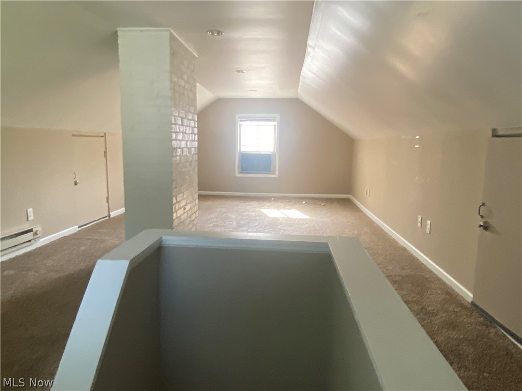 4218 Silsby Road University Heights, OH 44118 - Photo 21 of 27 Carpeted attic space featuring a window, painted brick accent wall, and sloped ceilings