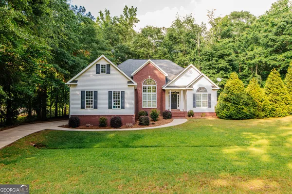 a front view of a house with yard and green space