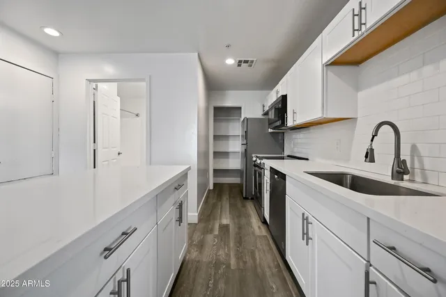 a kitchen with a sink a stove and cabinets