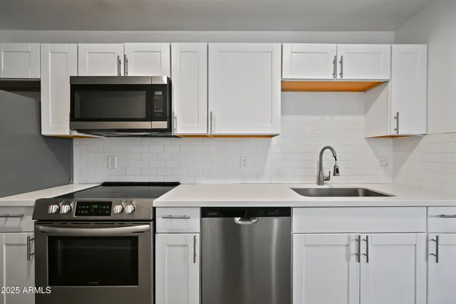 a kitchen with cabinets a sink and appliances