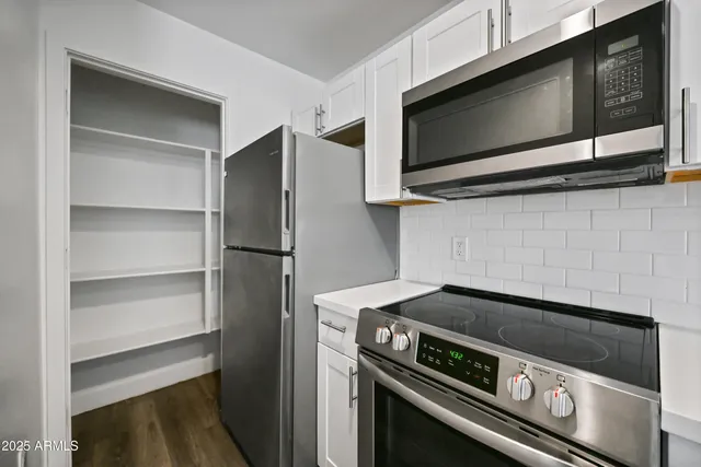 a kitchen with stainless steel appliances granite countertop a sink stove and microwave