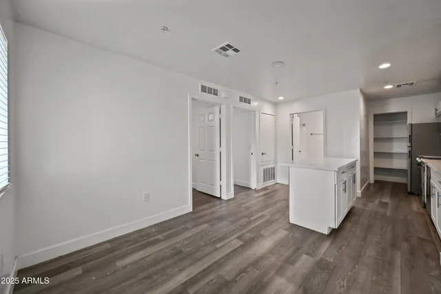 a view of an empty room with wooden floor