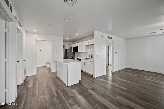 a view of a kitchen with wooden floor and a sink