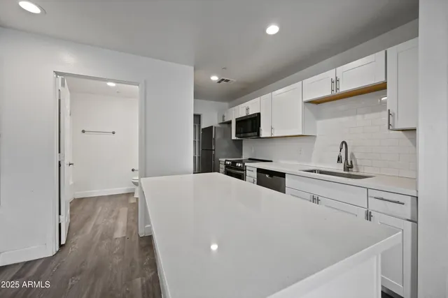a view of kitchen with wooden floor and electronic appliances