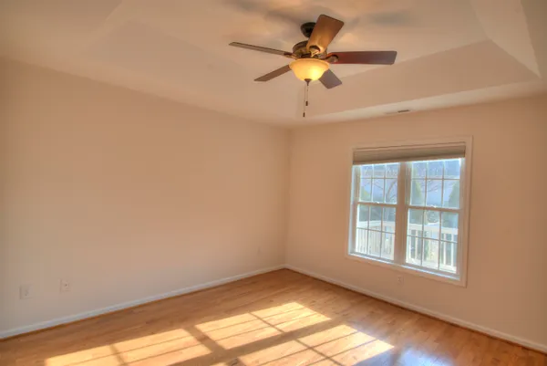an empty room with a window and a fan
