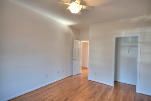 an empty room with wooden floor and windows