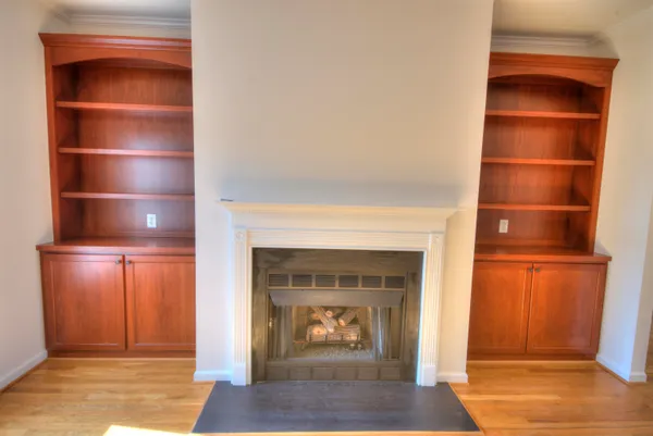 a living room with a fireplace and a walk in closet