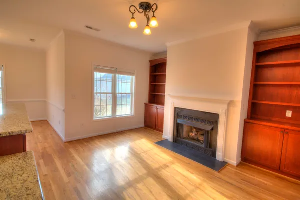 a view of an empty room with a fireplace and a window