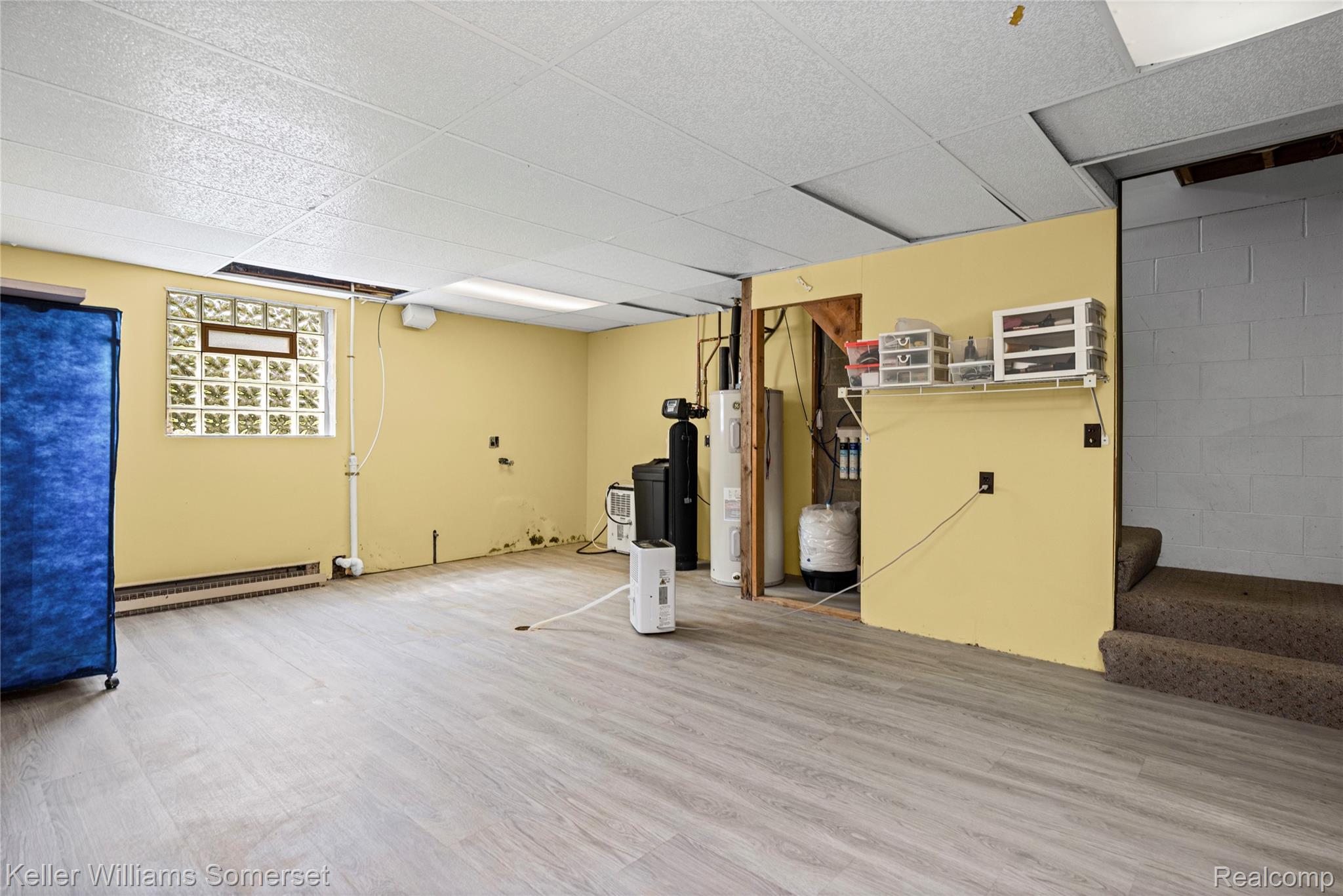2344 Rochester Road Leonard, MI 48367 - Photo 36 of 66 Spacious lower level featuring wood-finish flooring, painted walls, a glass block window, and a drop ceiling