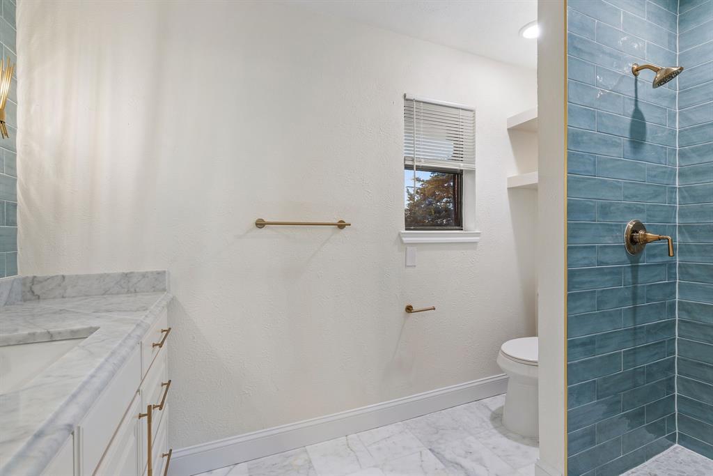 403 East 8th Street Prosper, TX 75078 - Photo 13 of 34 a bathroom with a granite countertop sink toilet and shower