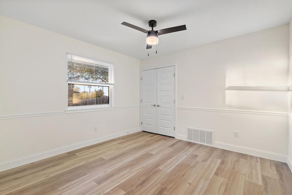 403 East 8th Street Prosper, TX 75078 - Photo 16 of 34 an empty room with wooden floor ceiling fan and windows