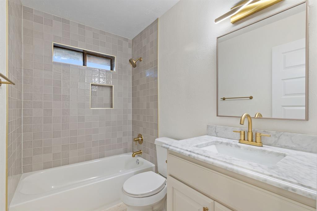 403 East 8th Street Prosper, TX 75078 - Photo 17 of 34 a bathroom with a granite countertop bathtub shower sink vanity mirror and toilet