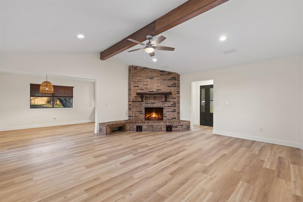 403 East 8th Street Prosper, TX 75078 - Photo 5 of 34 an empty room with wooden floor fireplace and fan
