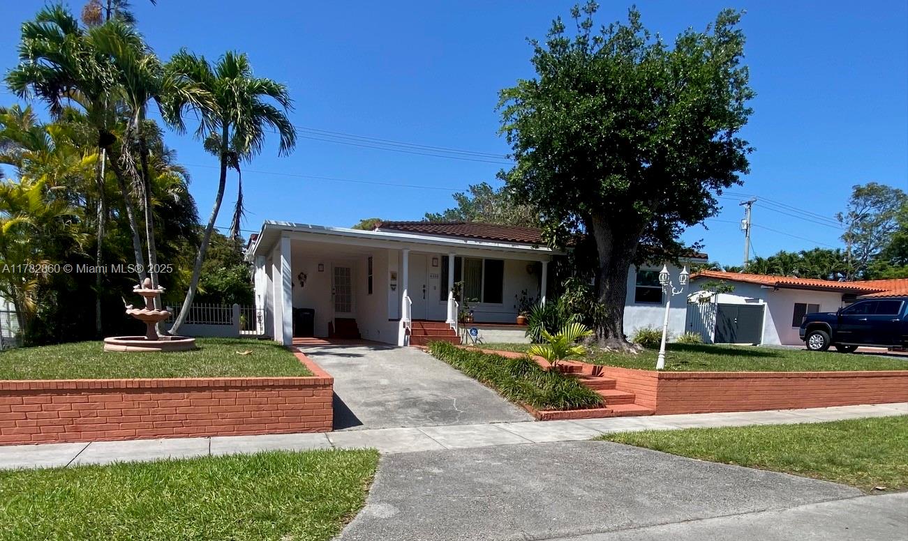 6331 Southwest 17th Street West Miami, FL 33155 - Photo 2 of 42 a front view of a house with garden and trees